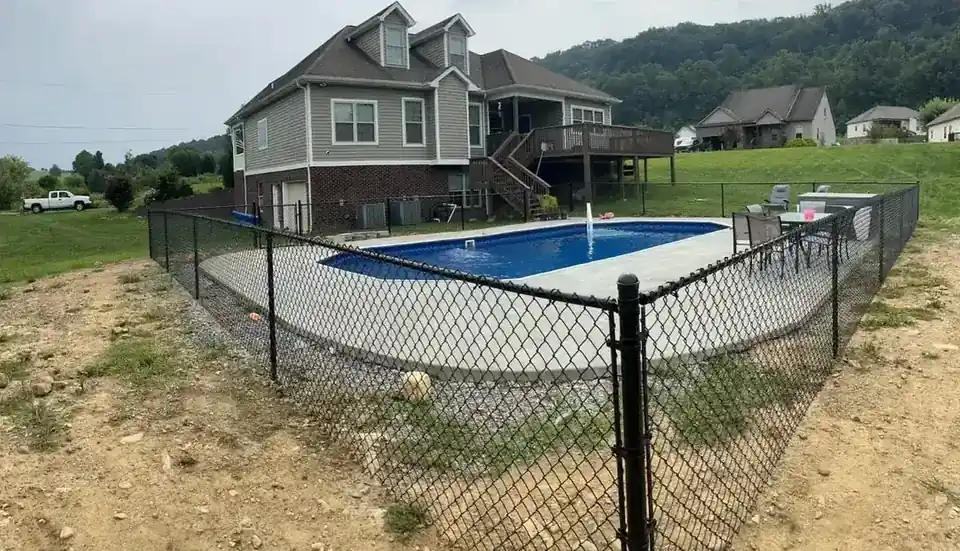 Black aluminum pool fence with a self-closing gate around a backyard pool in Valdosta